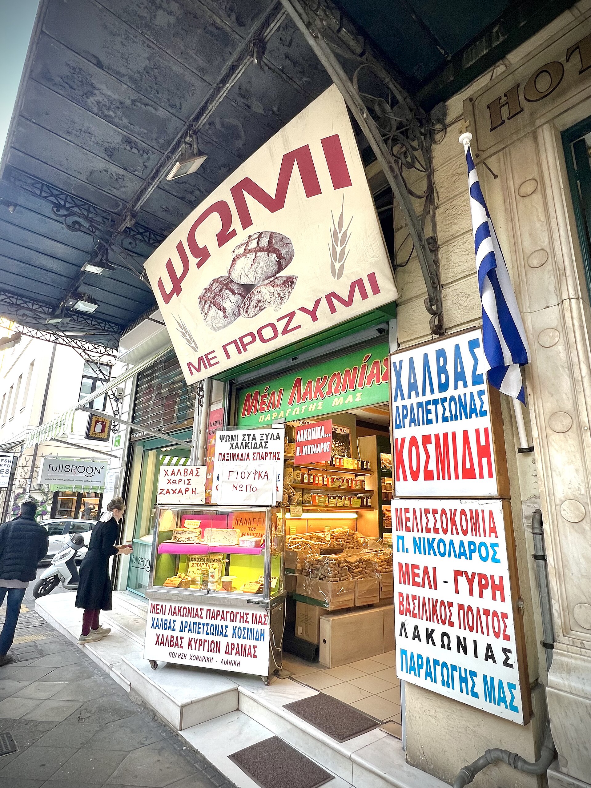 Bunte griechische Ladenschilder für Brot, Halva und Honig in Athen